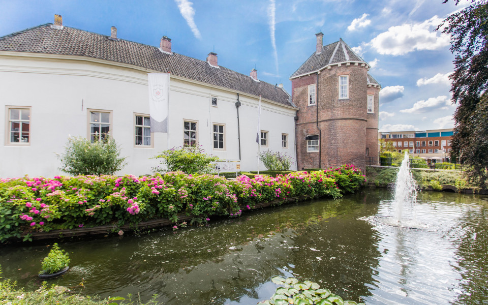 een groot gebouw met een fontein ervoor