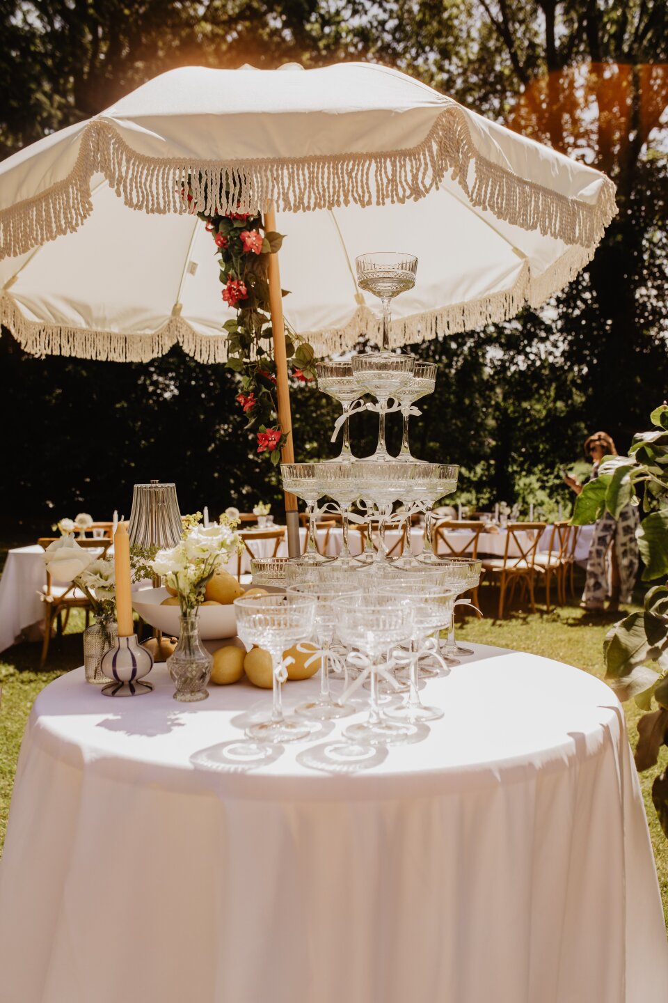 een tafel met een wit tafelkleed en een witte parasol