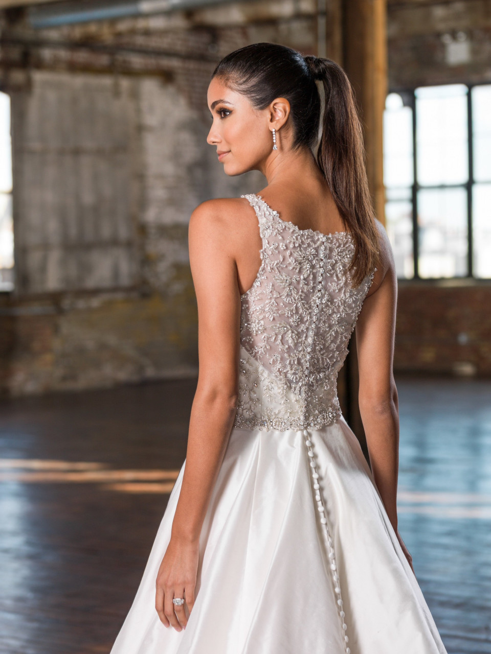 de achterkant van een vrouw die een trouwjurk draagt in een leeg magazijn