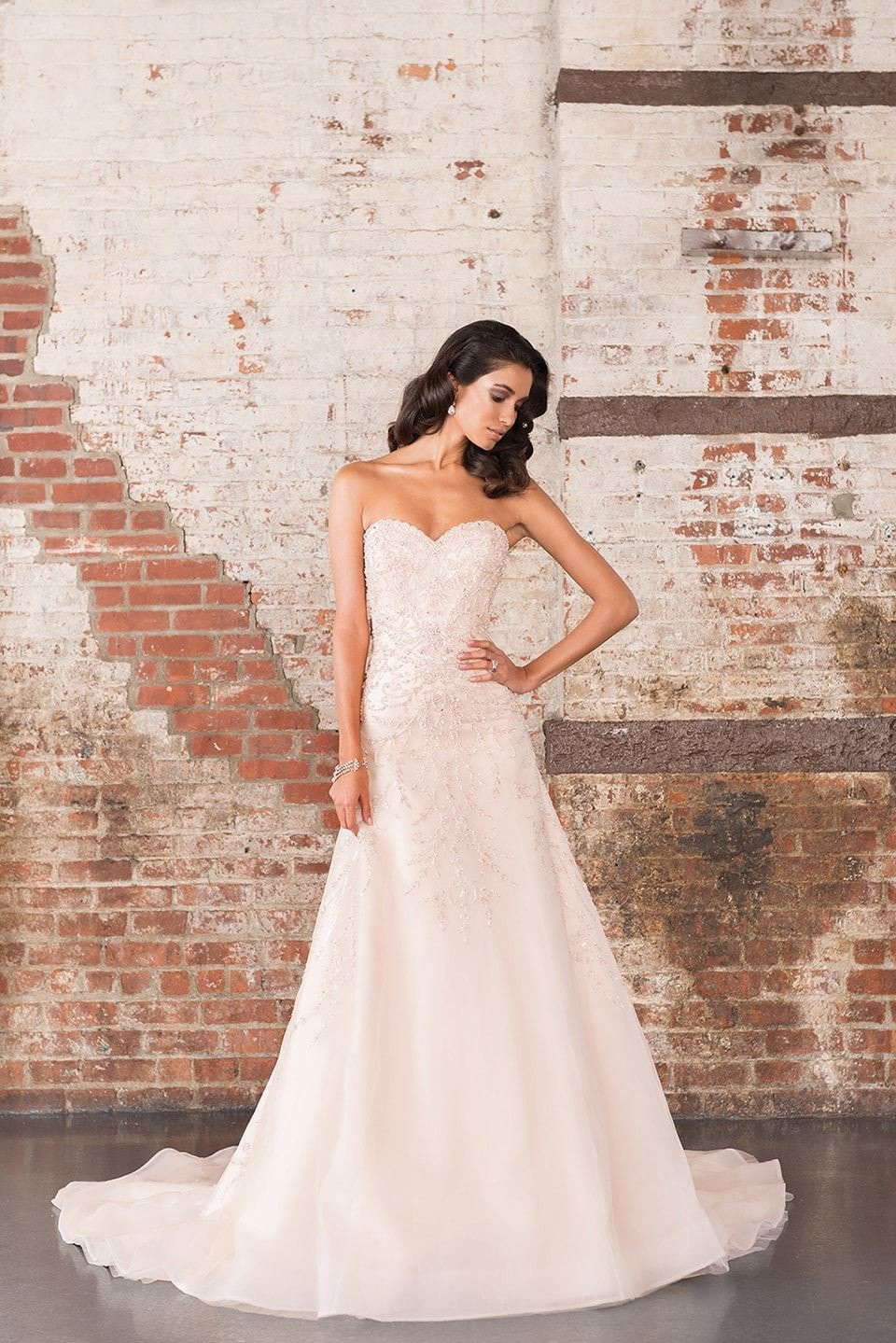 de trouwjurk is een strapless japon met een sweetheart halslijn en een sweetheart