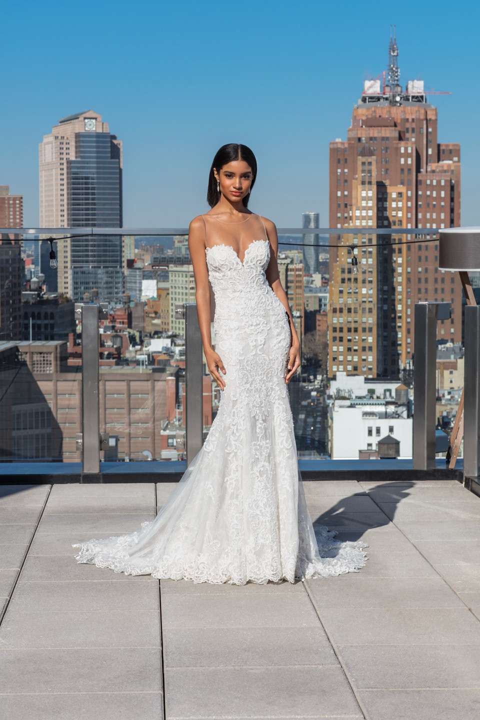 een bruid poseert op het dak van een gebouw met uitzicht op de stad