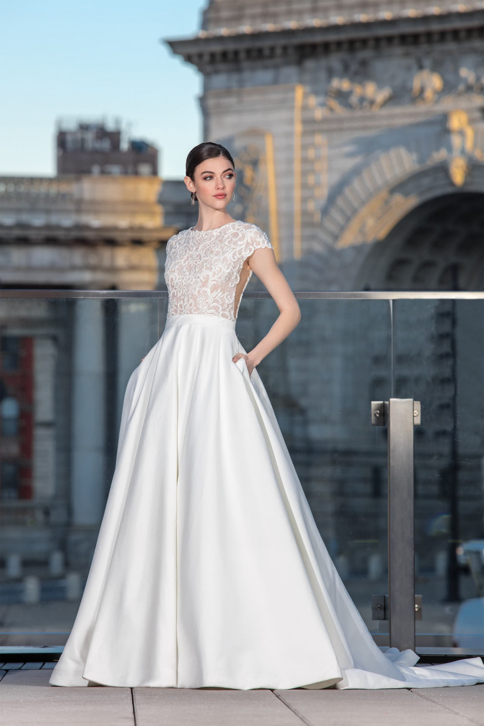 een bruid in een trouwjurk staand op een dak