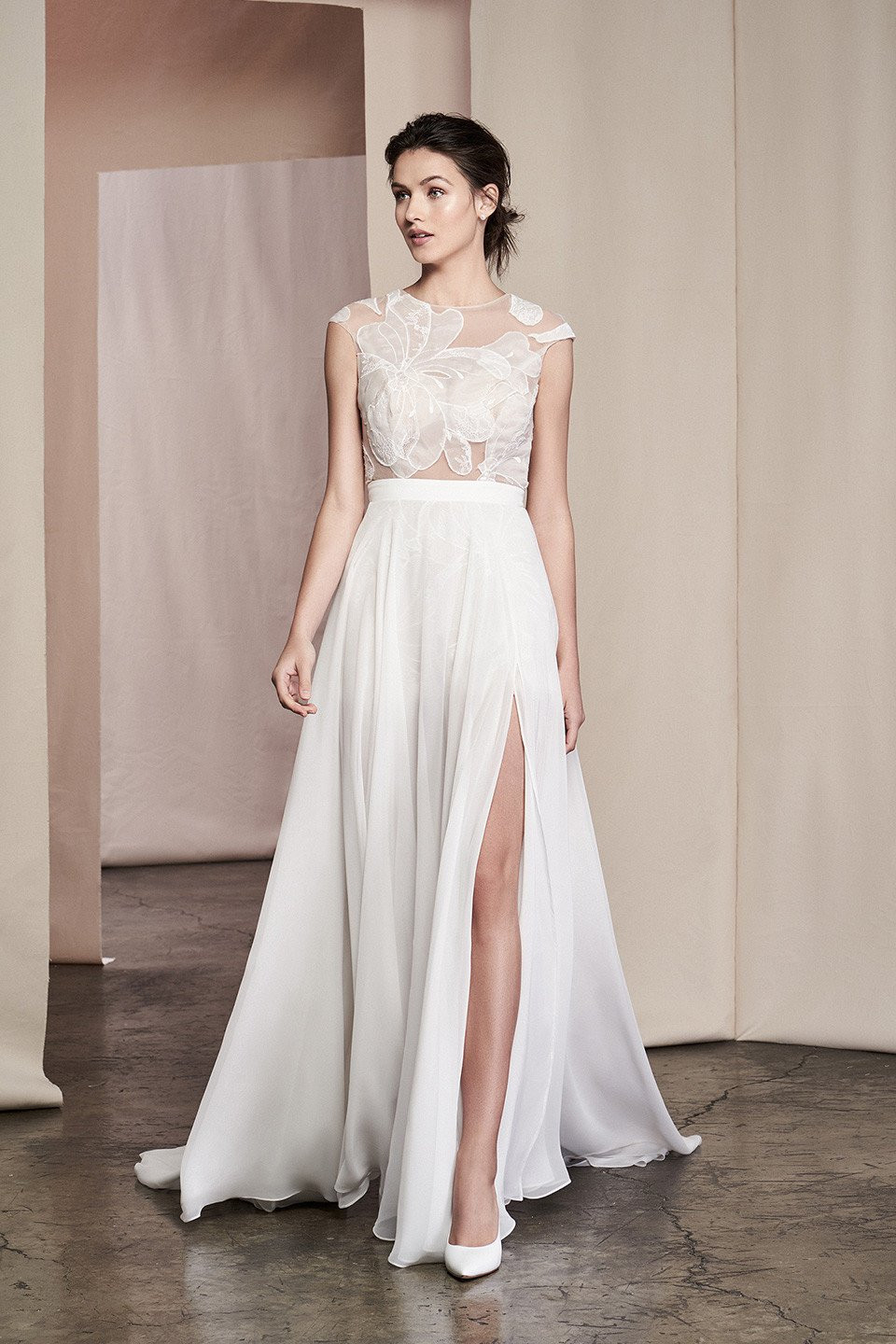 de bruidsjurk is een witte kanten en chiffon jurk met een hoge split