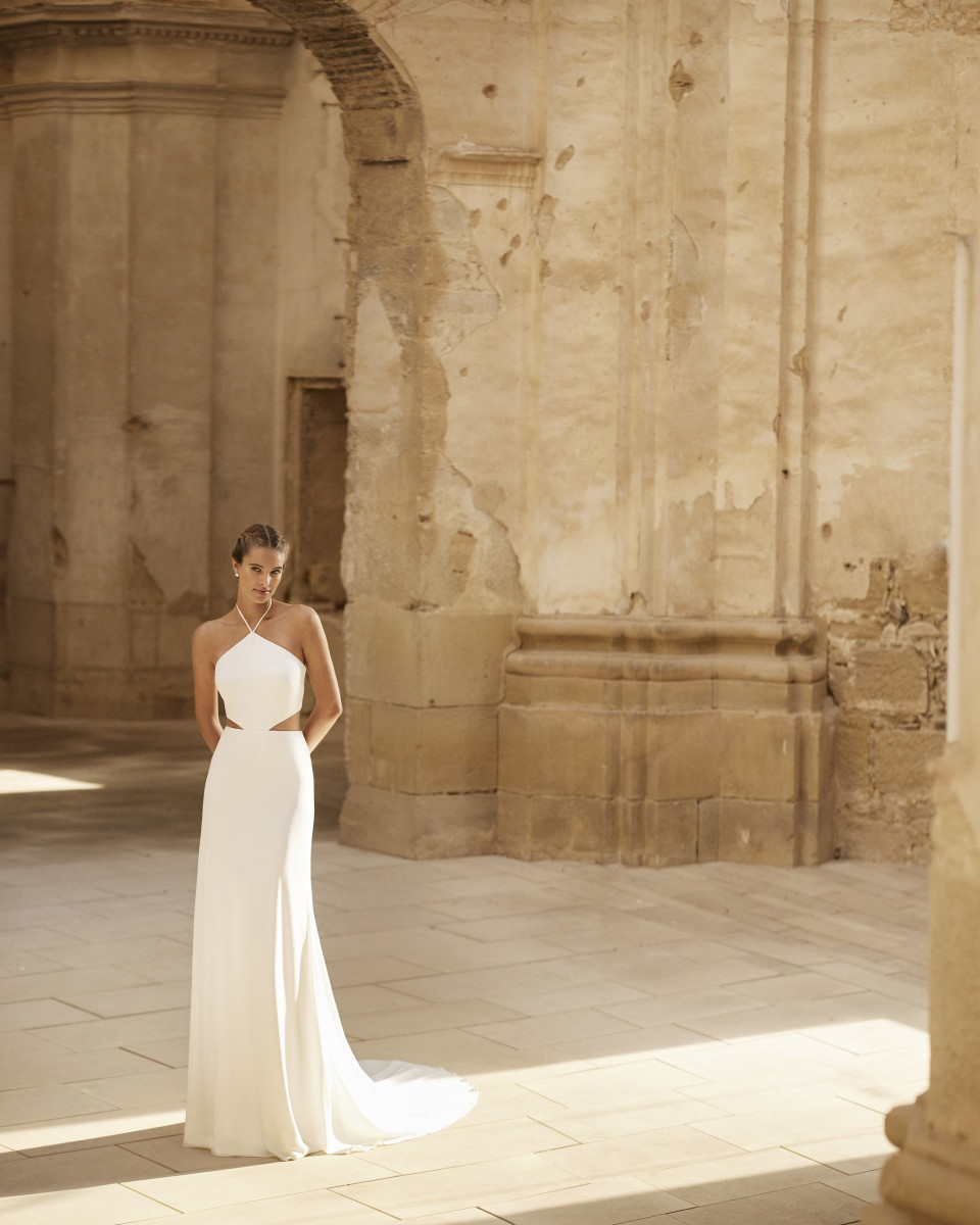 een vrouw in een trouwjurk staat in een oud gebouw