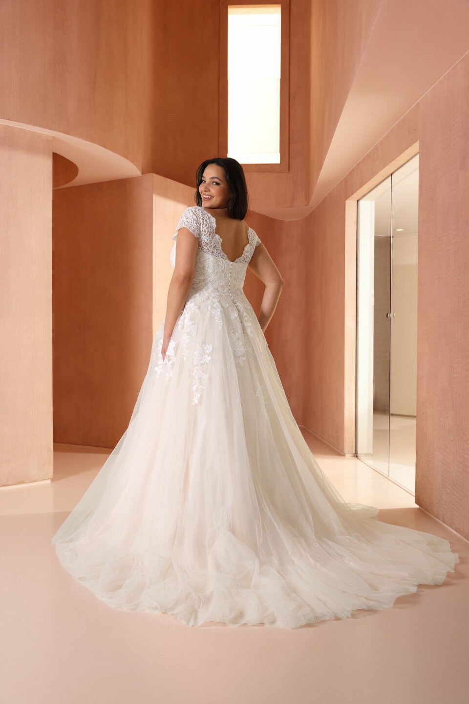 een vrouw in een trouwjurk die in een kamer staat