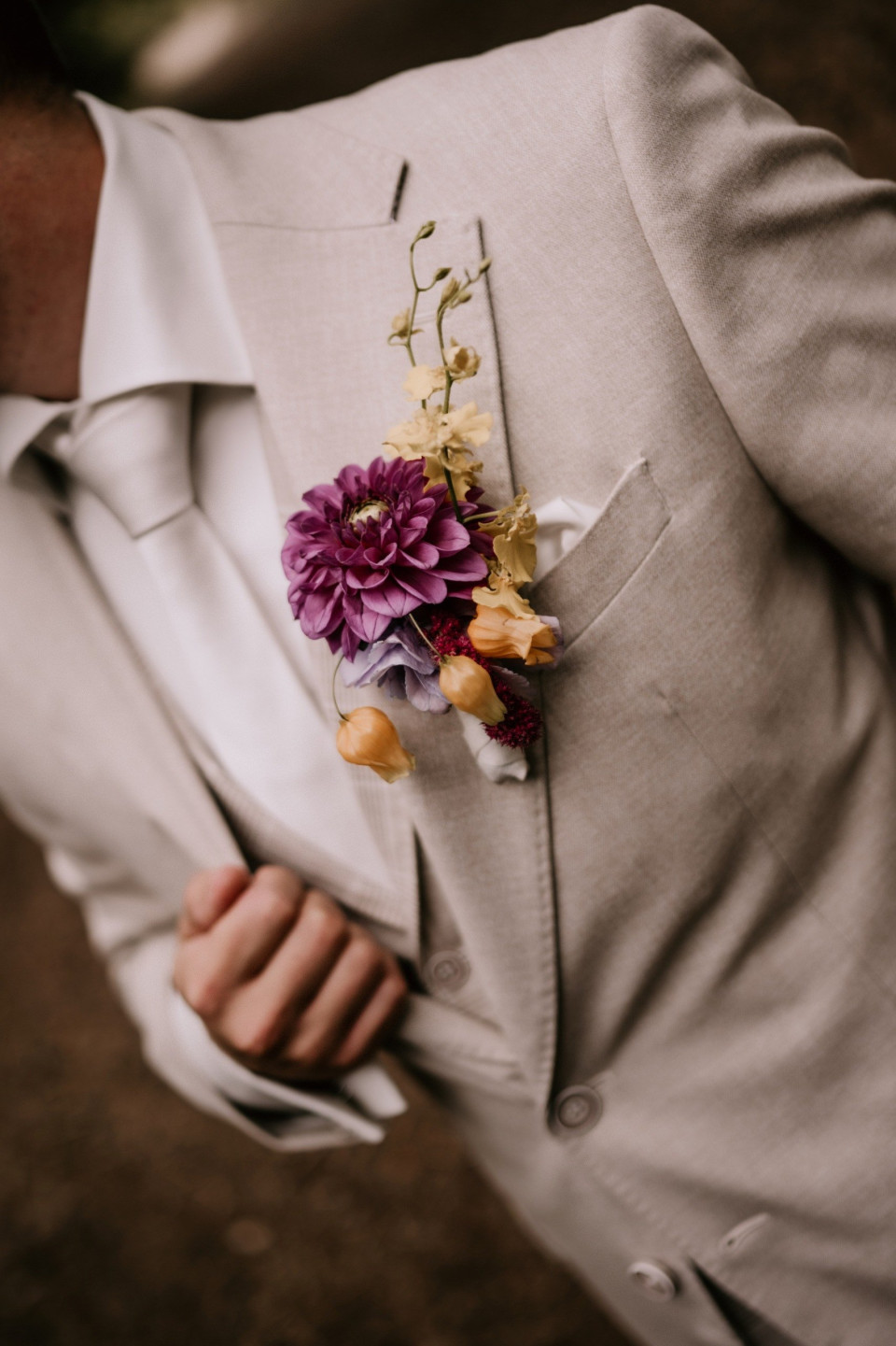 een man in een pak en stropdas met een bloem corsage