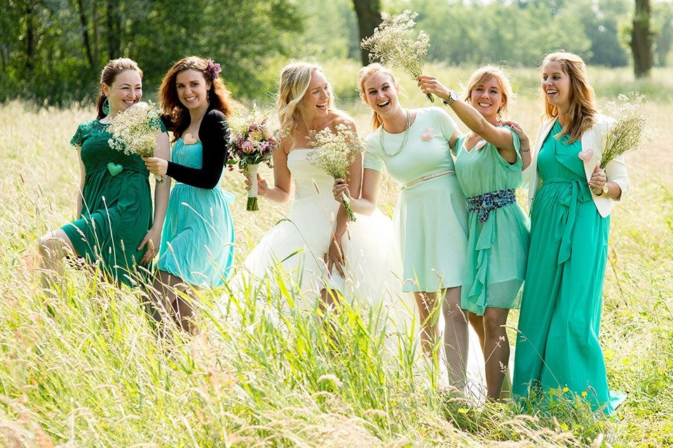 bruidsmeisjes in groene jurken op een veld