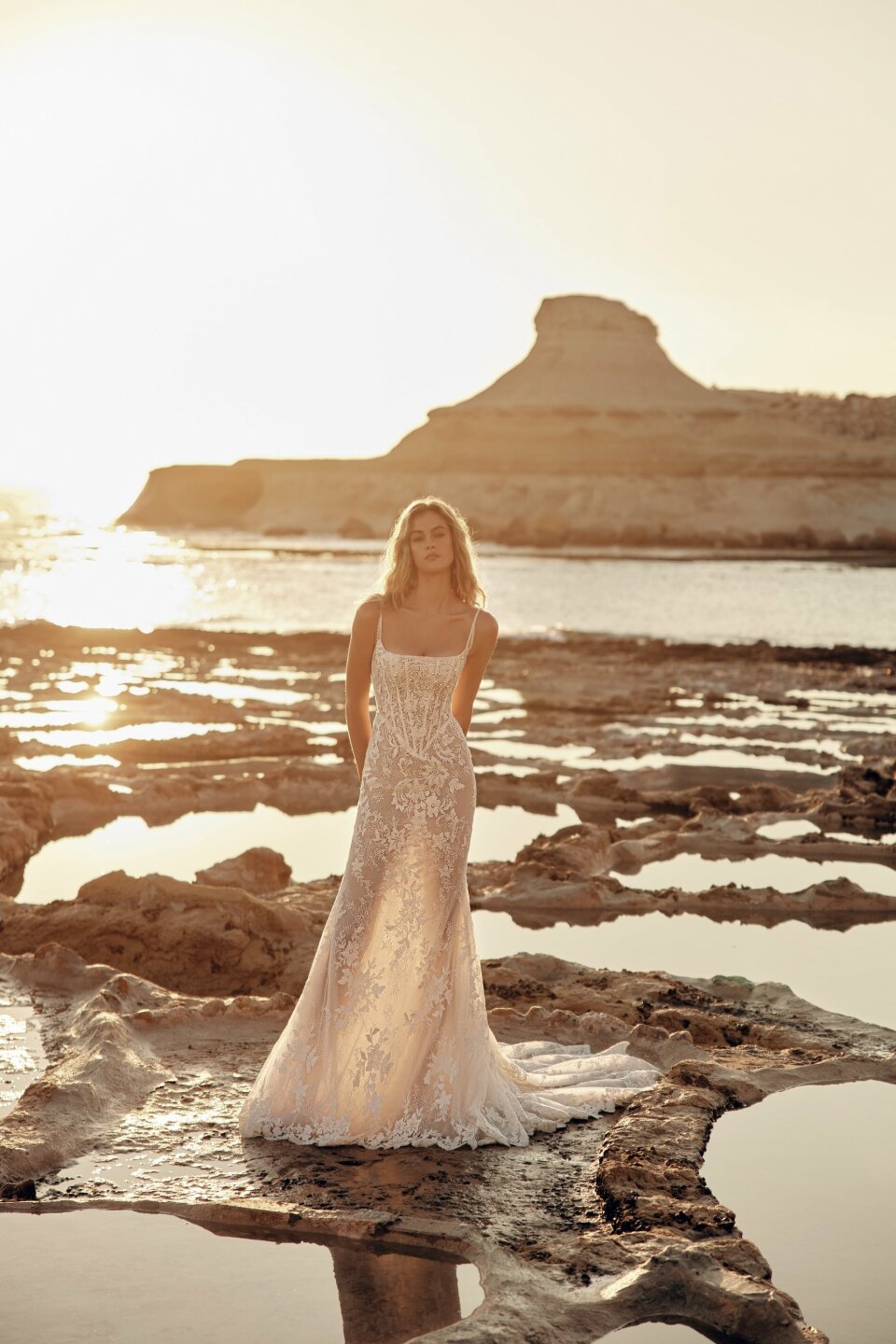 een vrouw in een trouwjurk die in het water staat