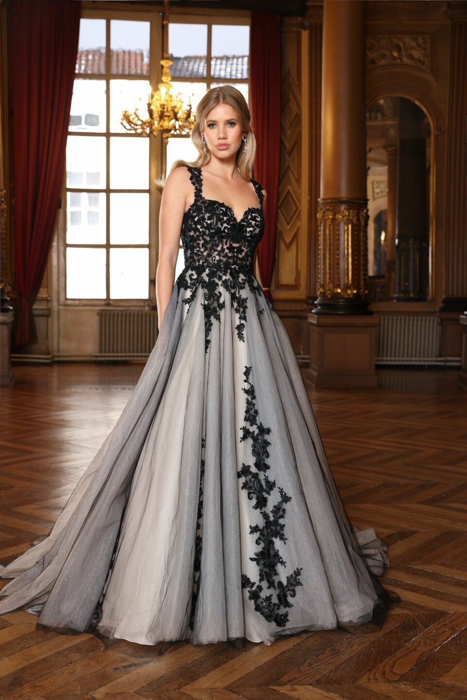 een vrouw in een zwart en grijs jurkje die in een kamer staat