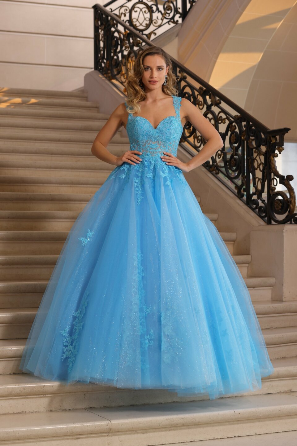 een vrouw in een blauwe jurk die op een trap staat