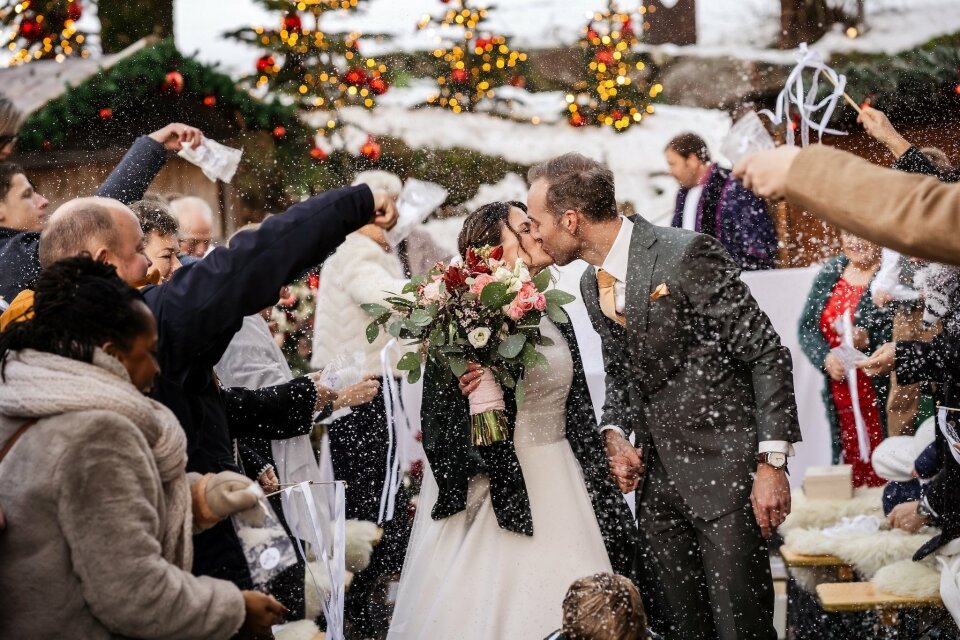 een bruid en bruidegom kussen terwijl ze het pad naar het altaar lopen