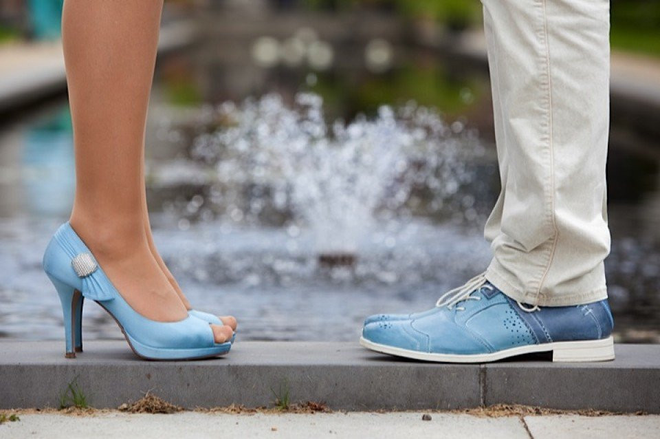 een man en vrouw die naast elkaar staan in blauwe schoenen