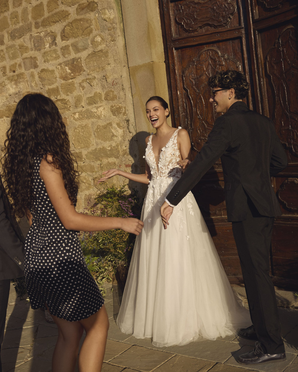 een man in een tuxedo die naast een vrouw in een trouwjurk staat