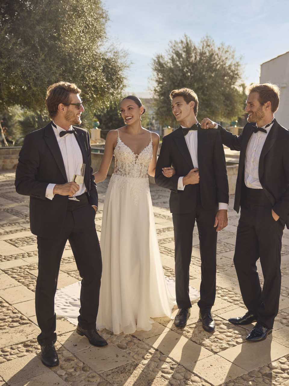 een paar mannen staan naast een vrouw in een trouwjurk