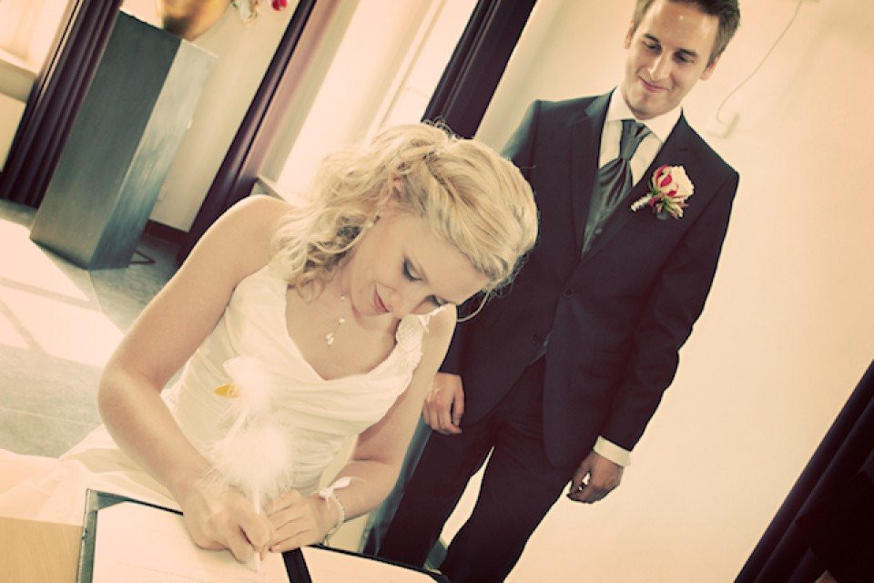 een man en een vrouw ondertekenen een trouwcertificaat