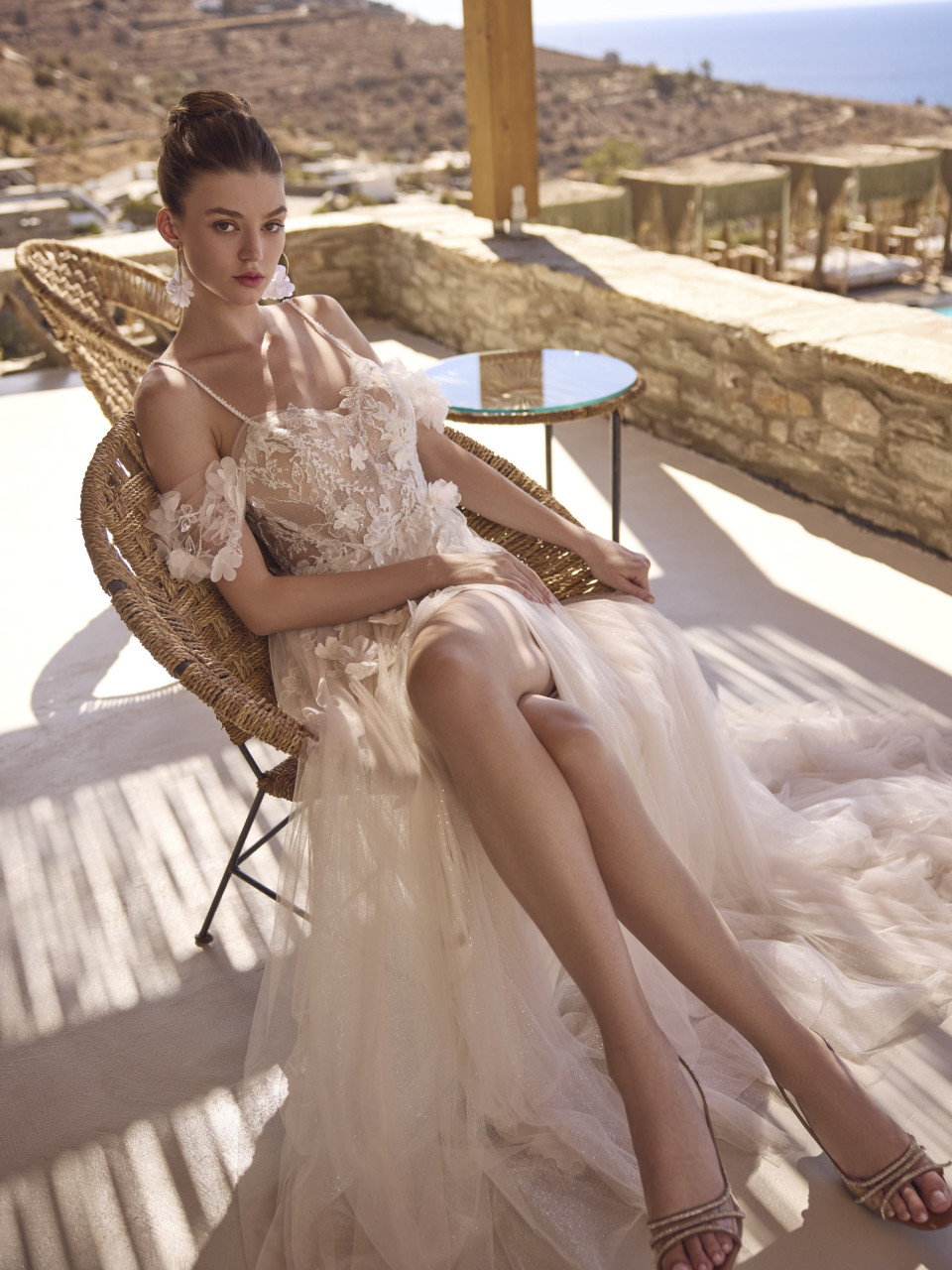 een vrouw die op een rotan stoel op een patio zit