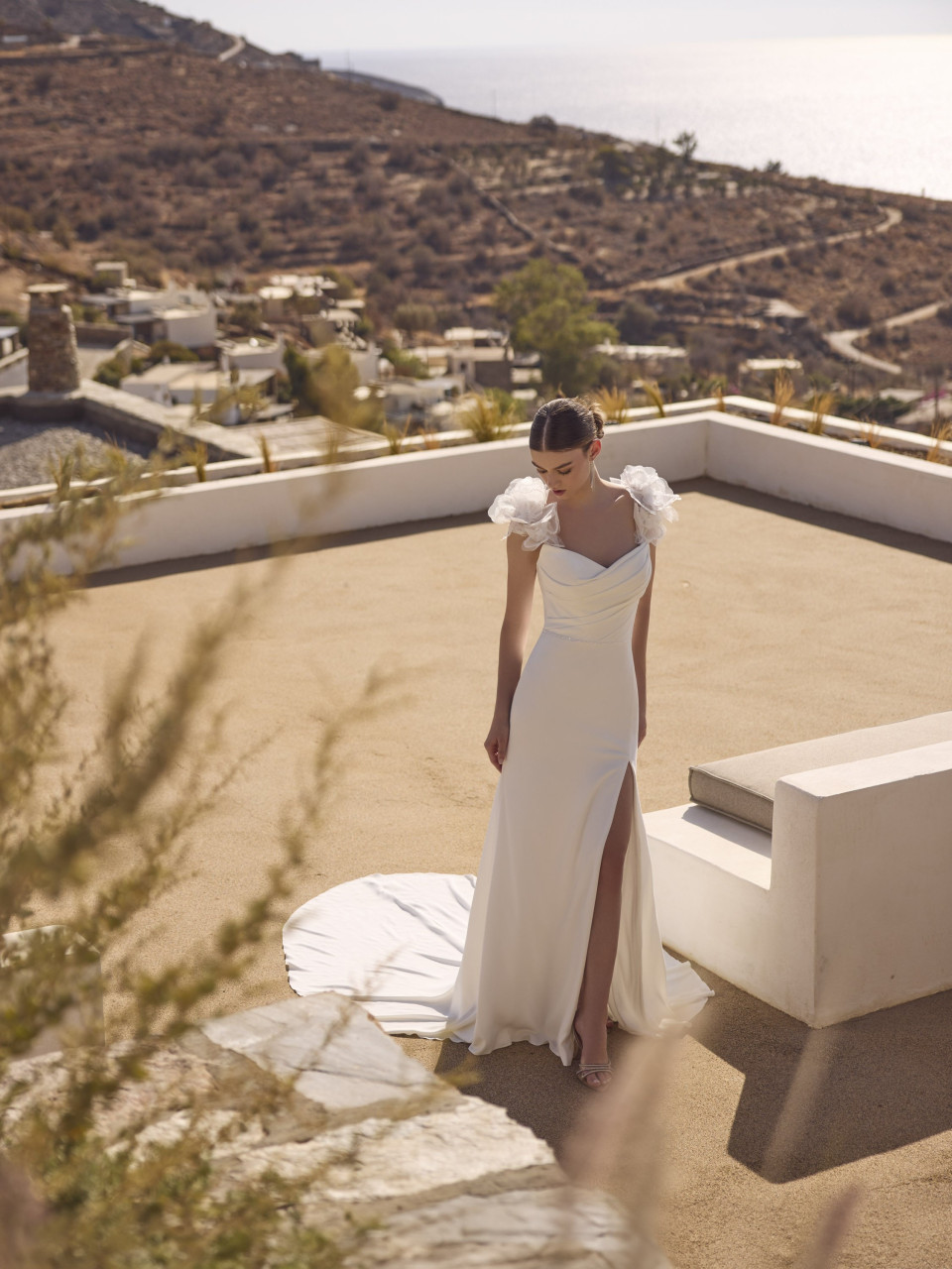 een vrouw in een witte jurk die op een dak staat