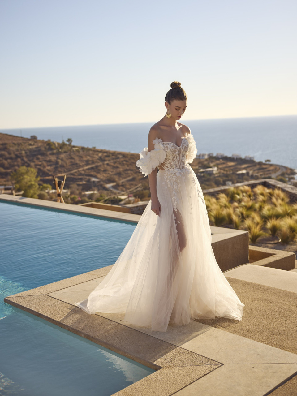 een vrouw in een trouwjurk die bij een zwembad staat