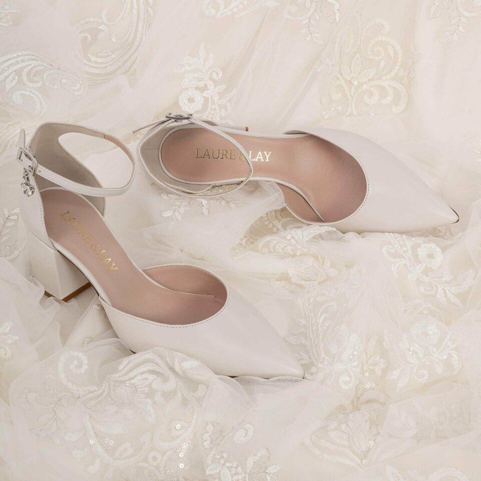 een close-up van een paar witte trouwschoenen