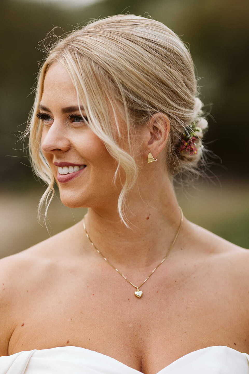 Opgestoken bruidskapsel met losse lokken en zachte bruidsmake-up