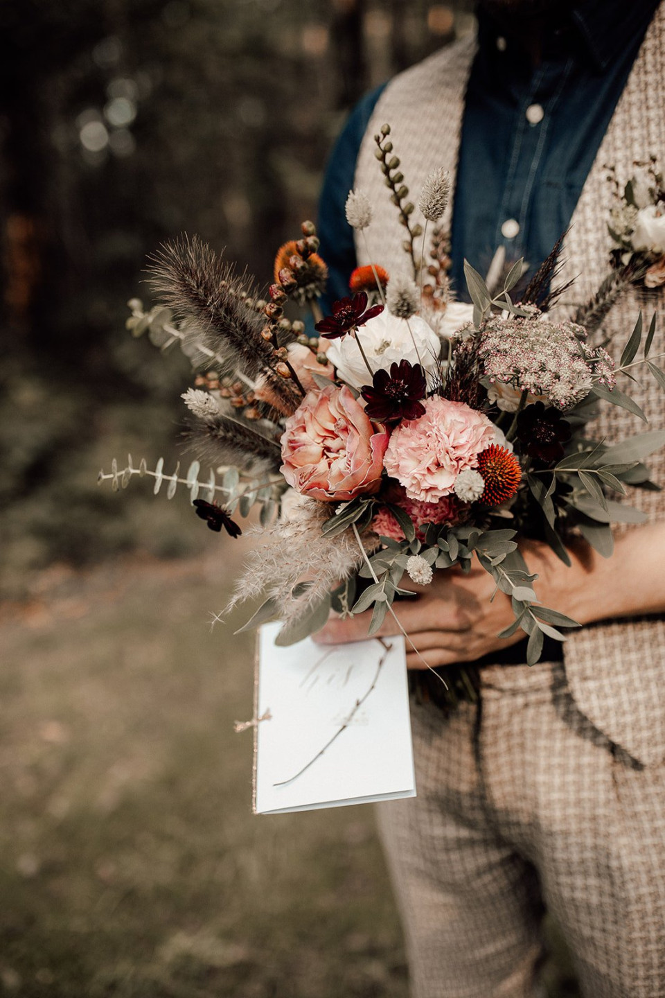 een man in een pak met een boeket bloemen