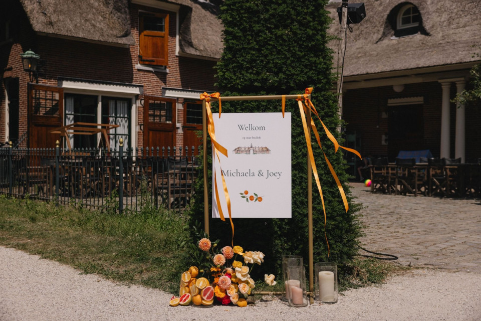 een bord met een bos bloemen erop voor een gebouw