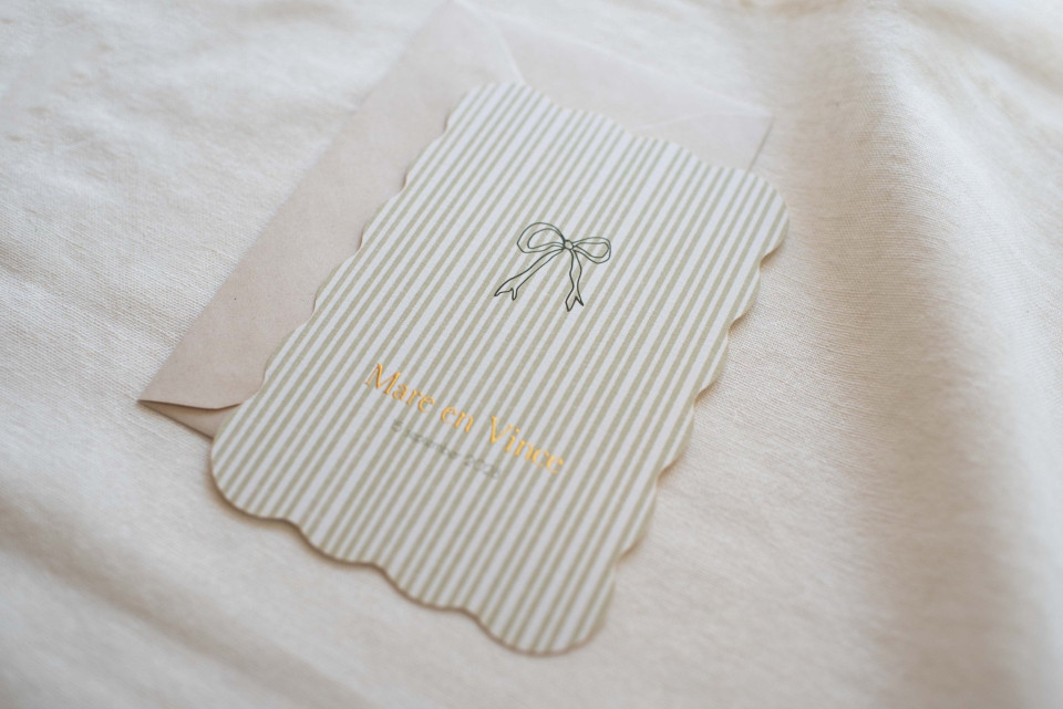 een briefje met een strik erop dat op een bed ligt