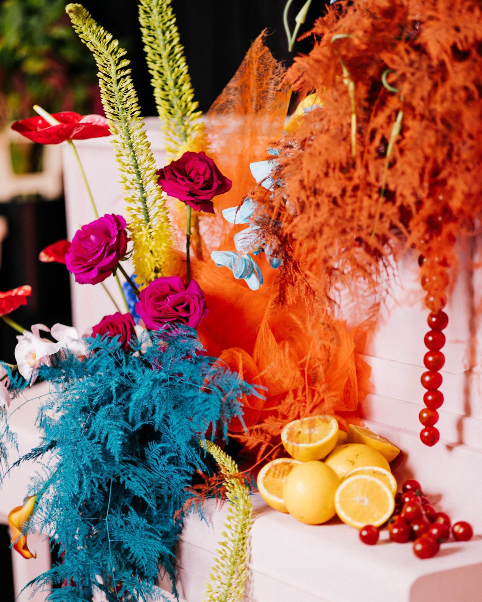 een arrangement van bloemen en fruit op een tafel