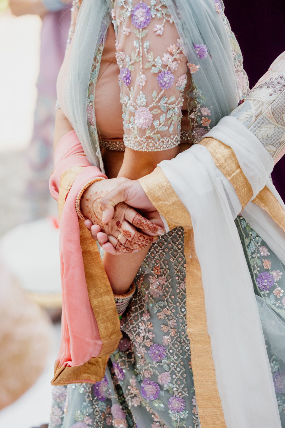 een close-up van de handen van een vrouw met een trouwring aan haar linkerhand en de rechterhand van een man aan de andere hand
