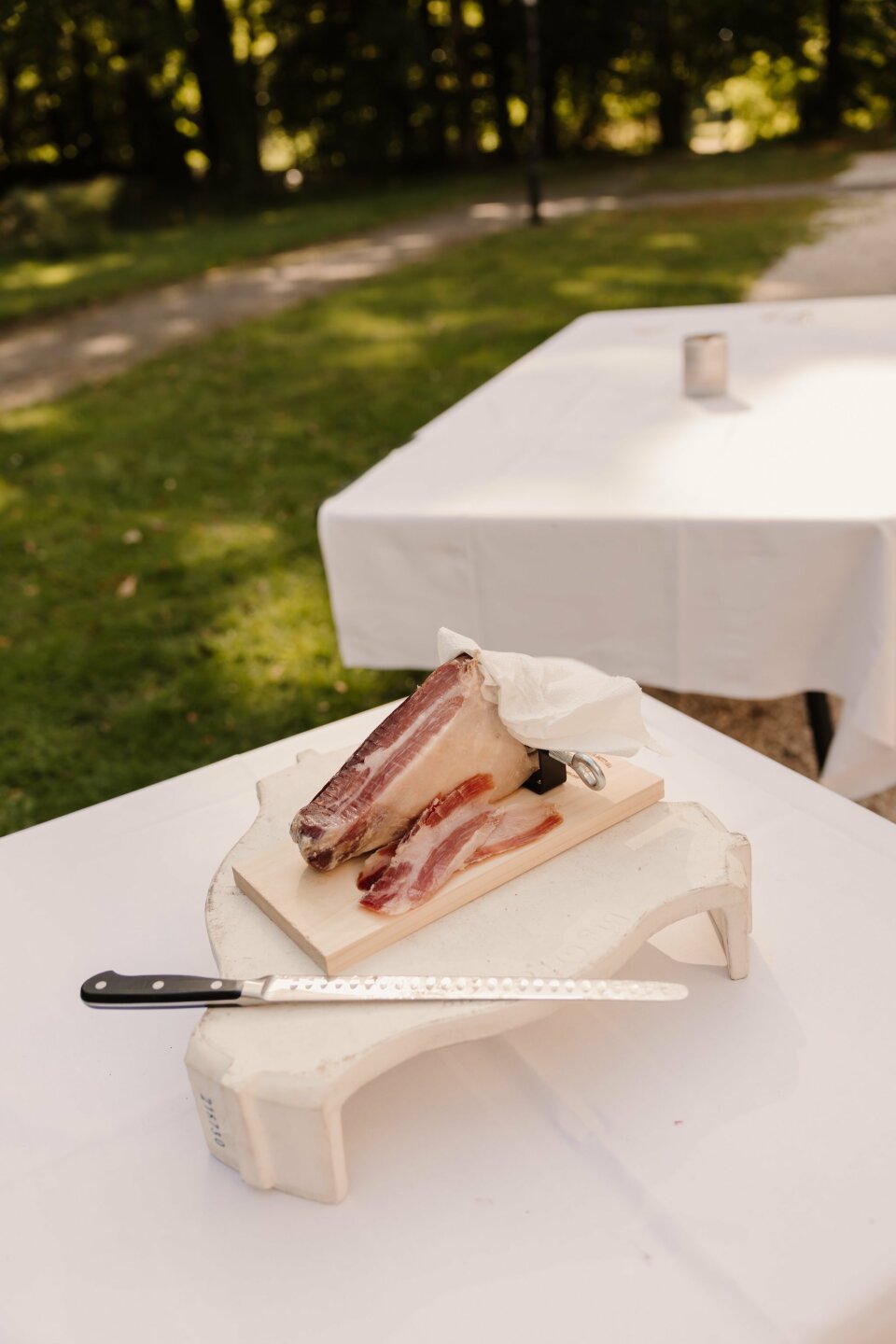 een stuk spek op een bord met een mes op een tafel