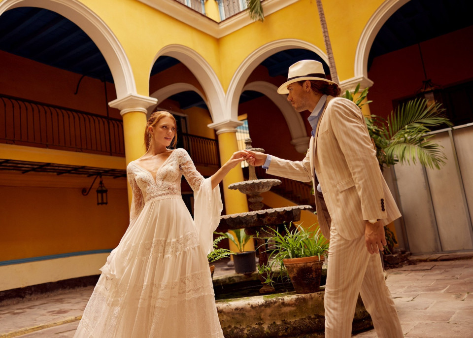 een bruid en bruidegom in een binnenplaats houden elkaars hand vast