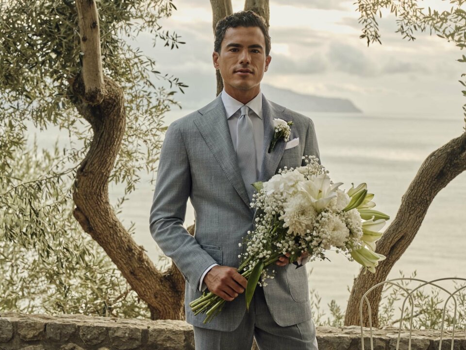 een man in een pak die een boeket bloemen vasthoudt