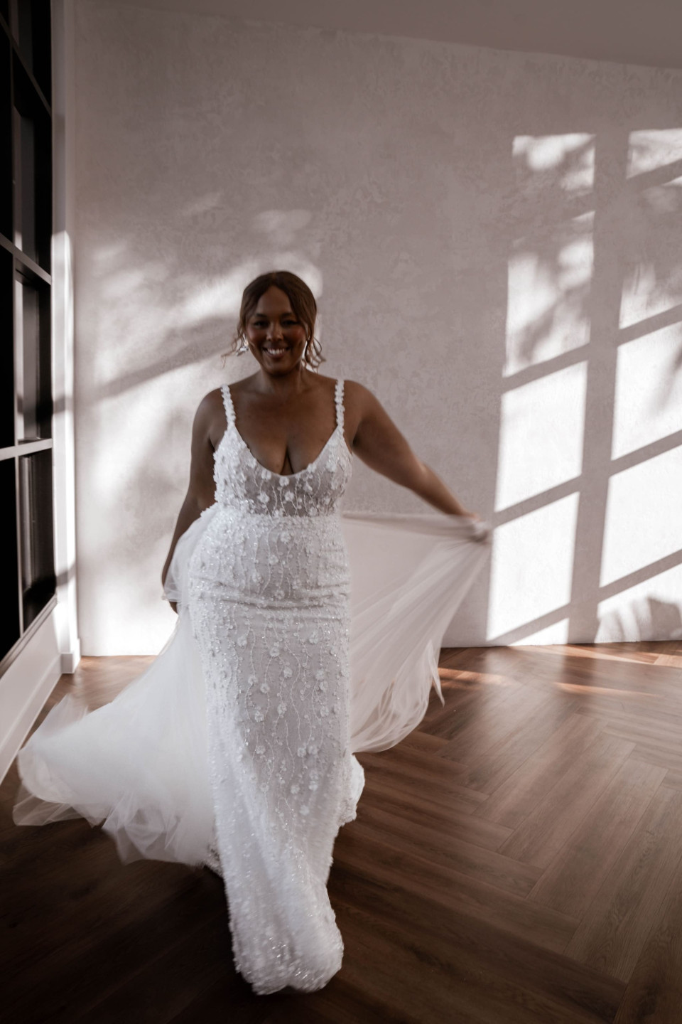 een bruid loopt in een grote kamer met zonlicht