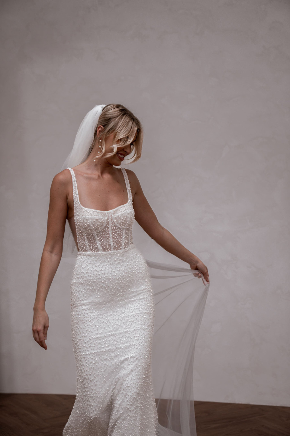 een bruid in een witte trouwjurk en sluier