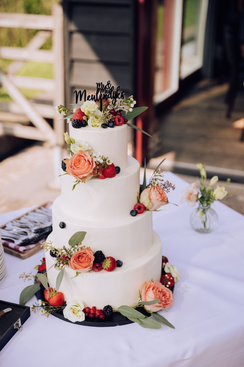 de bruidstaart op de tafel klaar om geserveerd te worden aan de gasten op de buitenbruiloft in een landelijke omgeving
