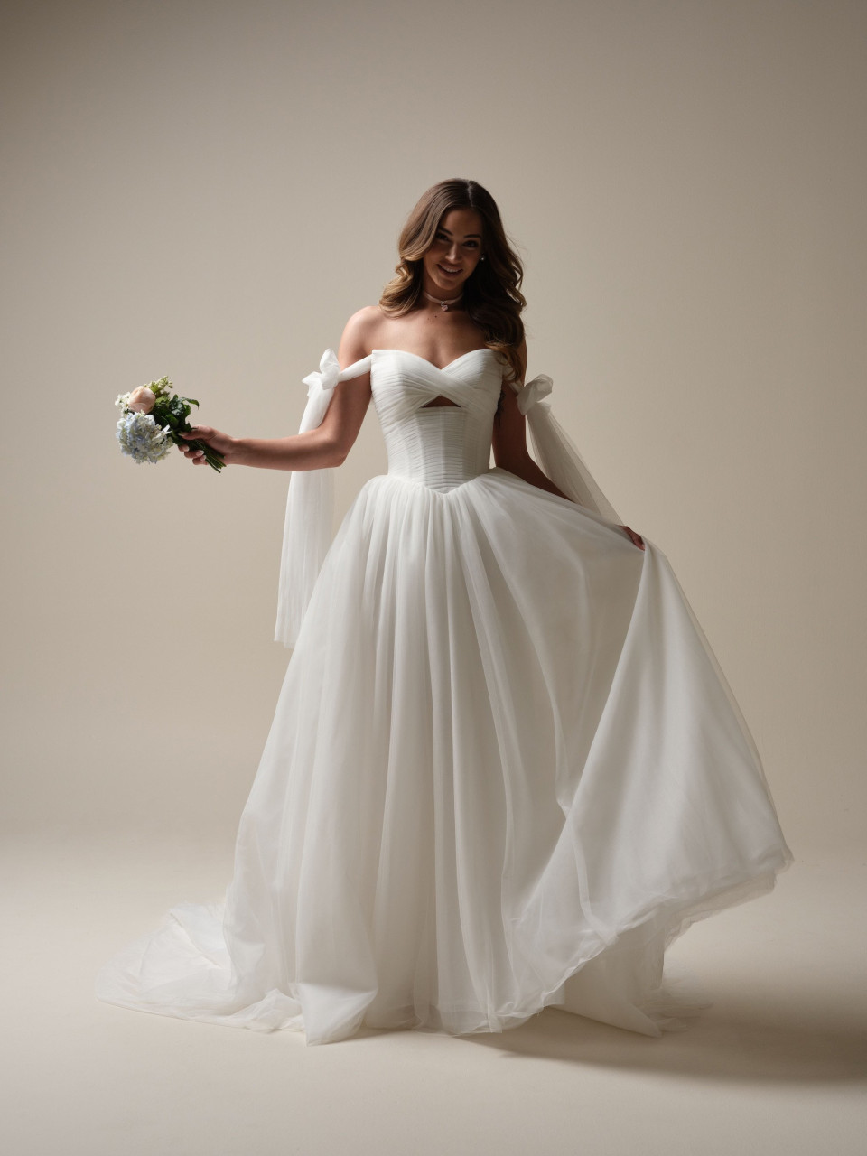 een vrouw in een trouwjurk poseert voor een foto