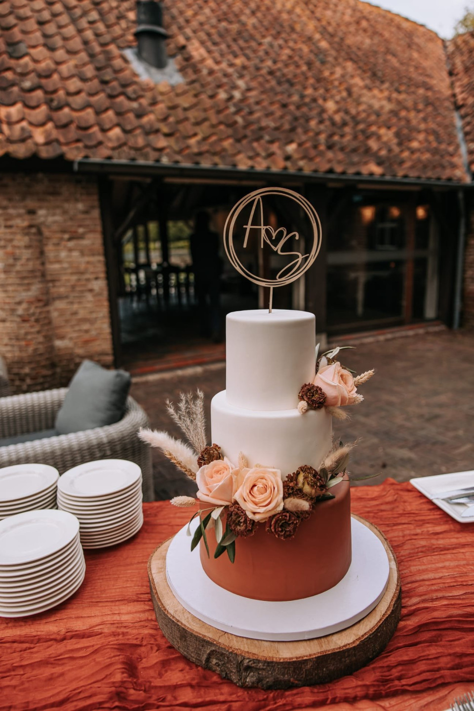 een bruidstaart op een tafel met borden en bestek