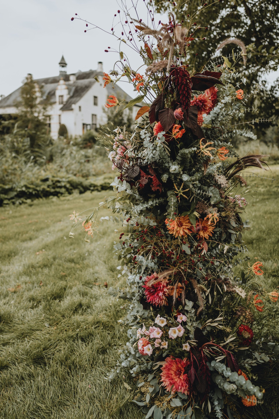 een hoge bloemstuk in het gras