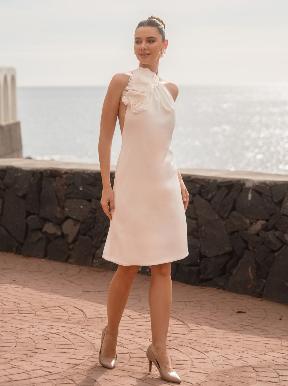 een vrouw in een witte jurk poserend voor een foto