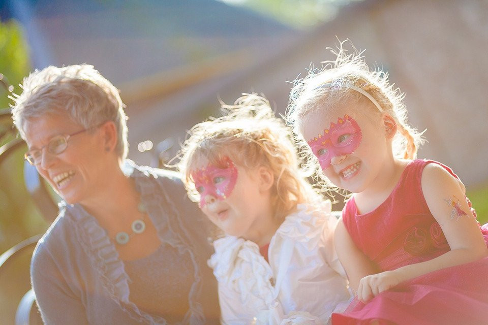 een vrouw en twee kleine meisjes die roze maskers dragen