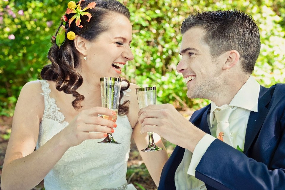 een bruid en bruidegom toosten met champagneglazen