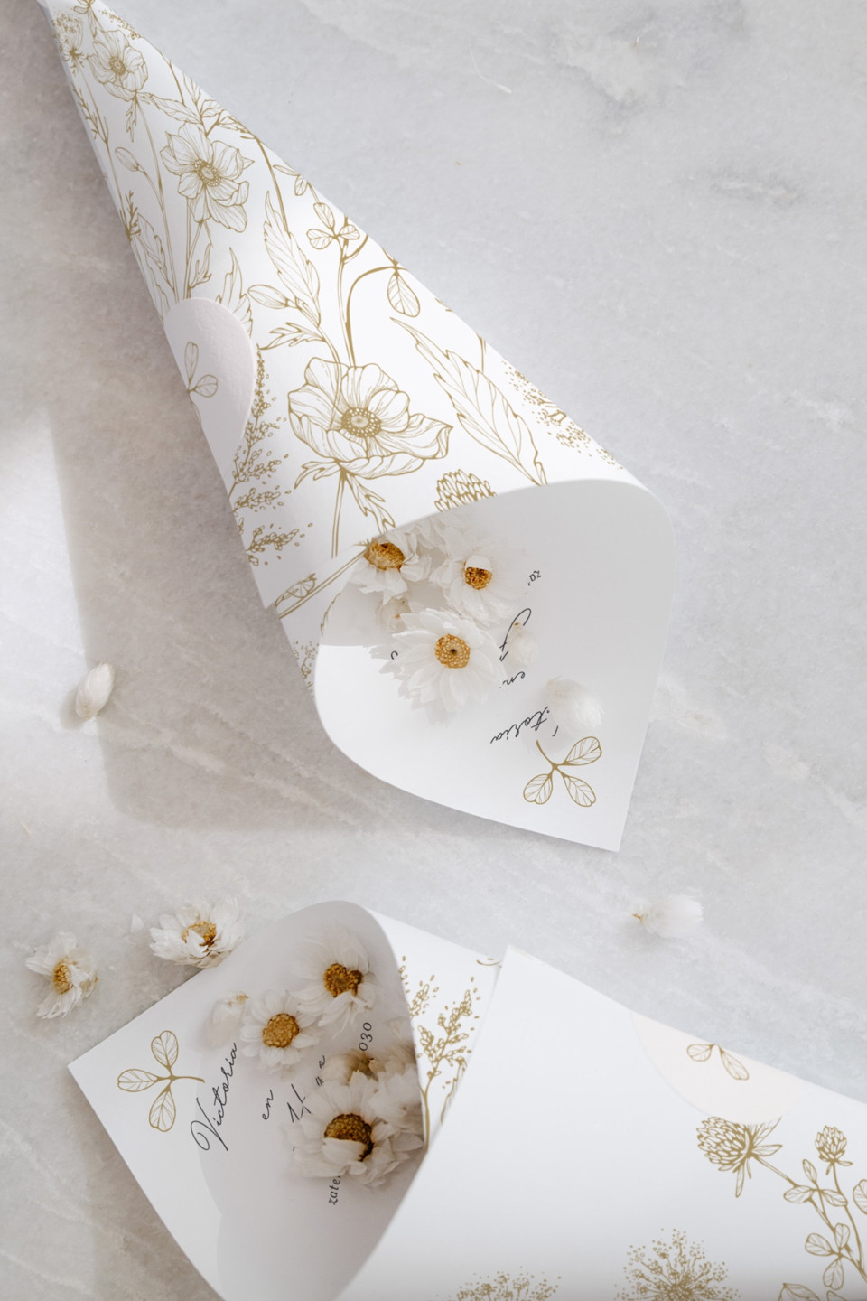 een witte kegel met gouden folie en bloemen erop