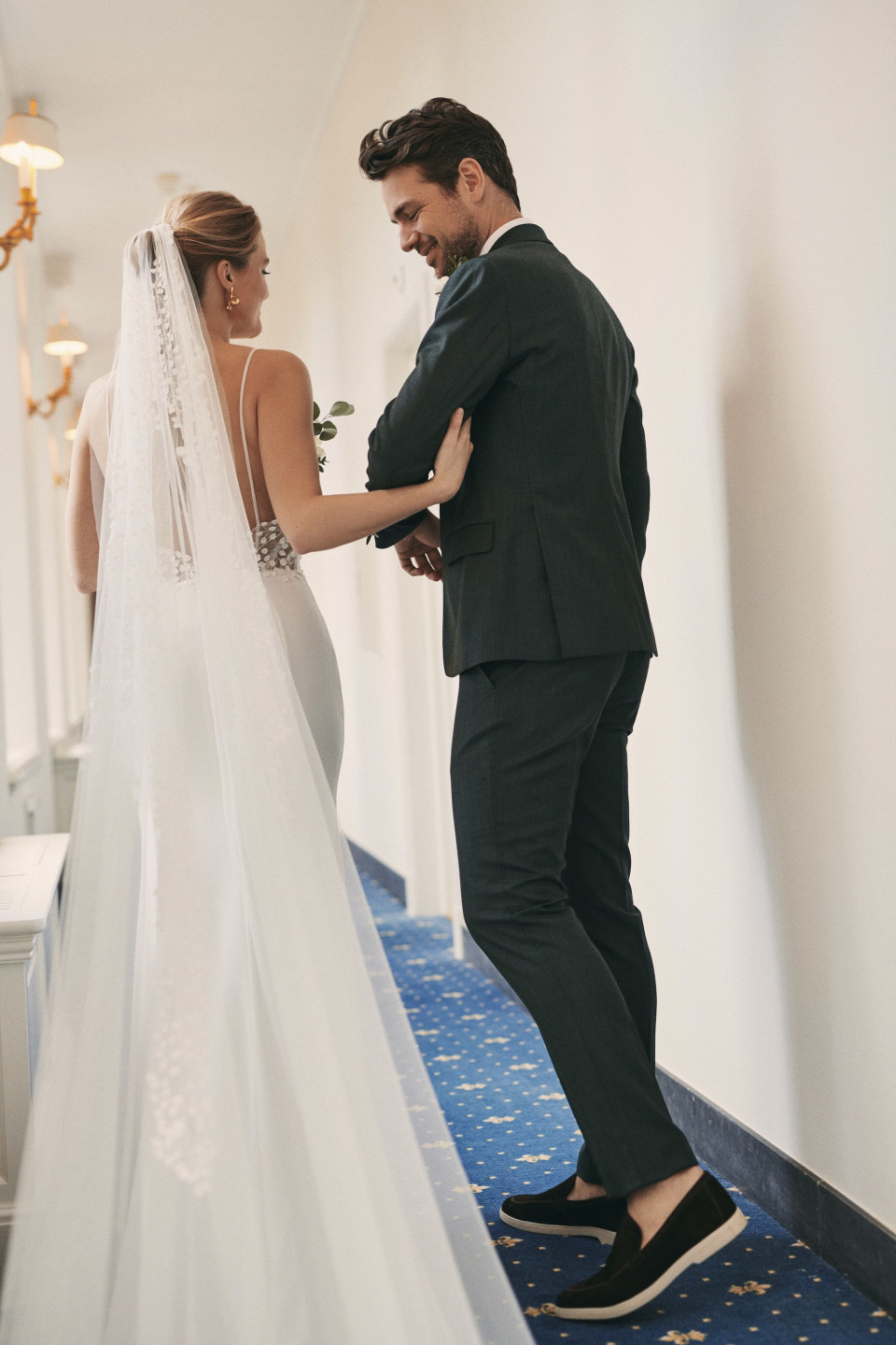 een bruid en bruidegom lopen door een gang