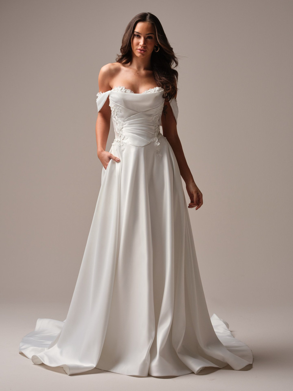 een vrouw in een trouwjurk poseert voor een foto