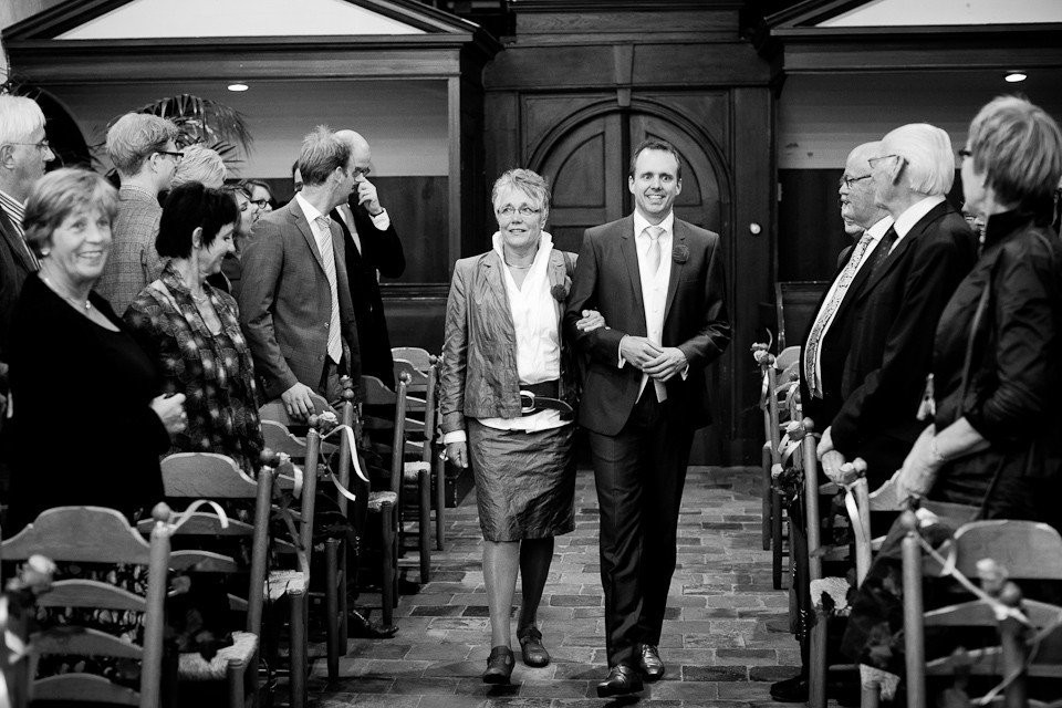 een man en vrouw lopen het gangpad van een kerk af