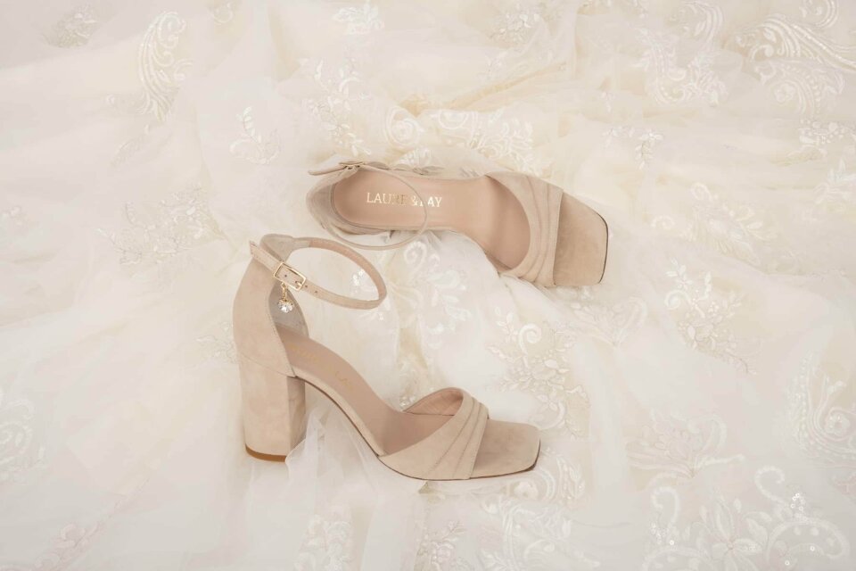 de trouwjurk en schoenen van de bruid op het bed