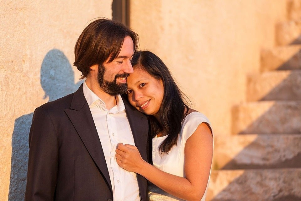 een man en vrouw die poseren voor een foto voor een muur