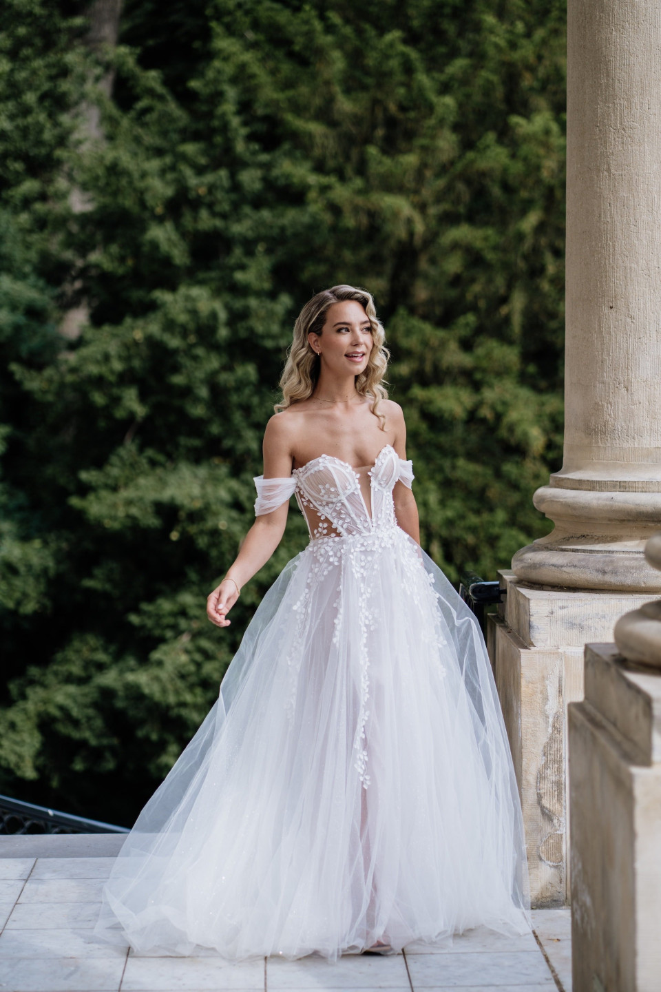 een bruid in een trouwjurk die op een stenen pad staat