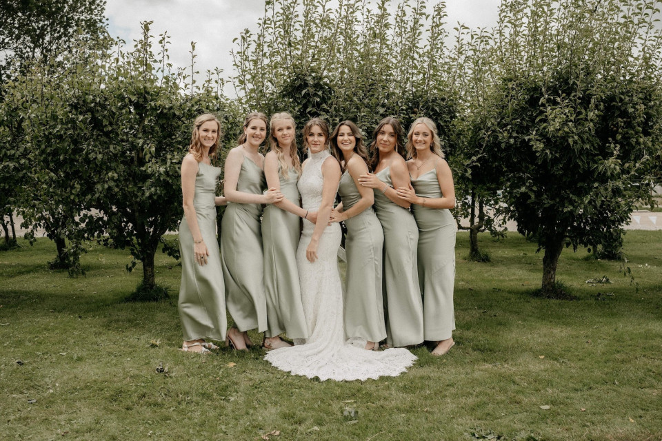 de bruid en haar bruidsmeisjes poseren voor een foto