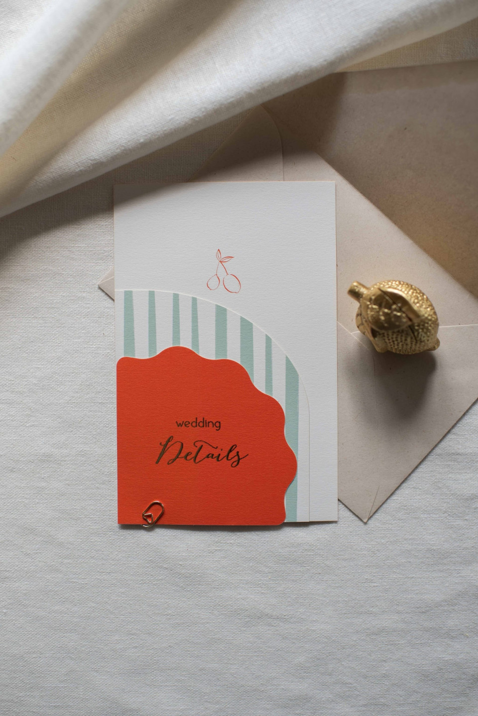 een trouwuitnodiging met een gouden munt bovenop